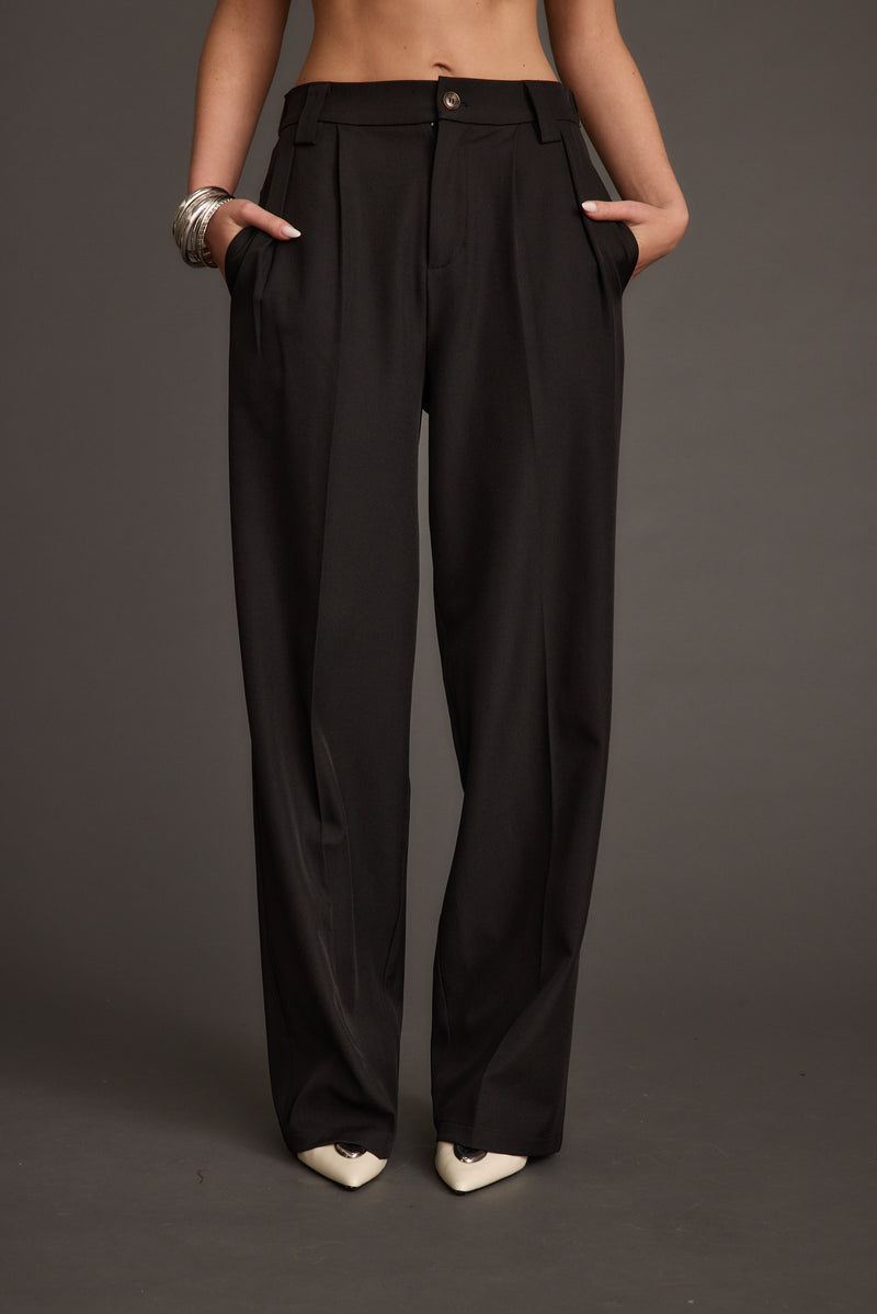 Back view of the black trousers showing the silhouette and fit.