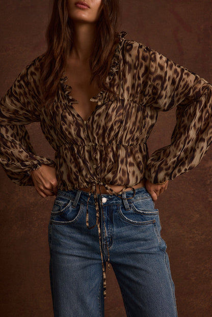 Full-length view of the leopard print blouse showing the drape and movement.