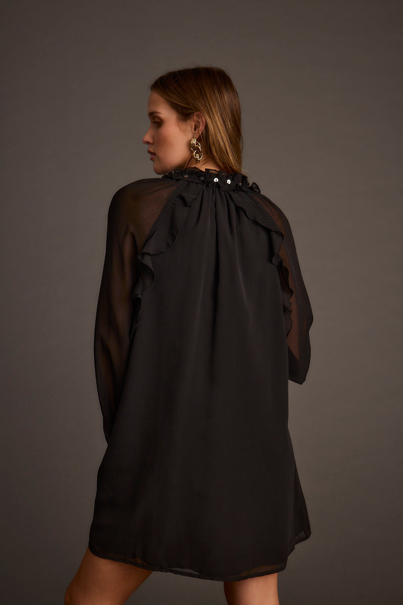 Back view of the black chiffon mini dress showing the silhouette and fit.