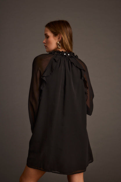 Back view of the black chiffon mini dress showing the silhouette and fit.