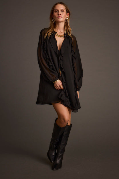 Full-length view of the black mini dress showing the drape and movement.