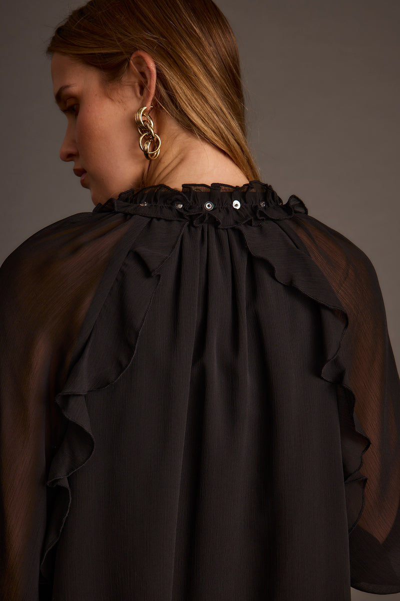 Lifestyle shot of the black mini dress styled for day-to-night versatility.