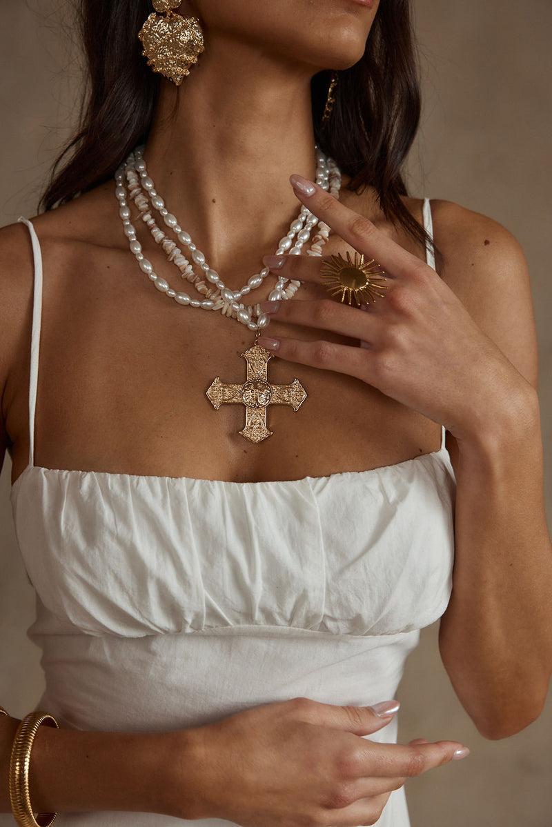 Gold pearl necklace with refined detailing, a pearl cross necklace gold accessory staple.