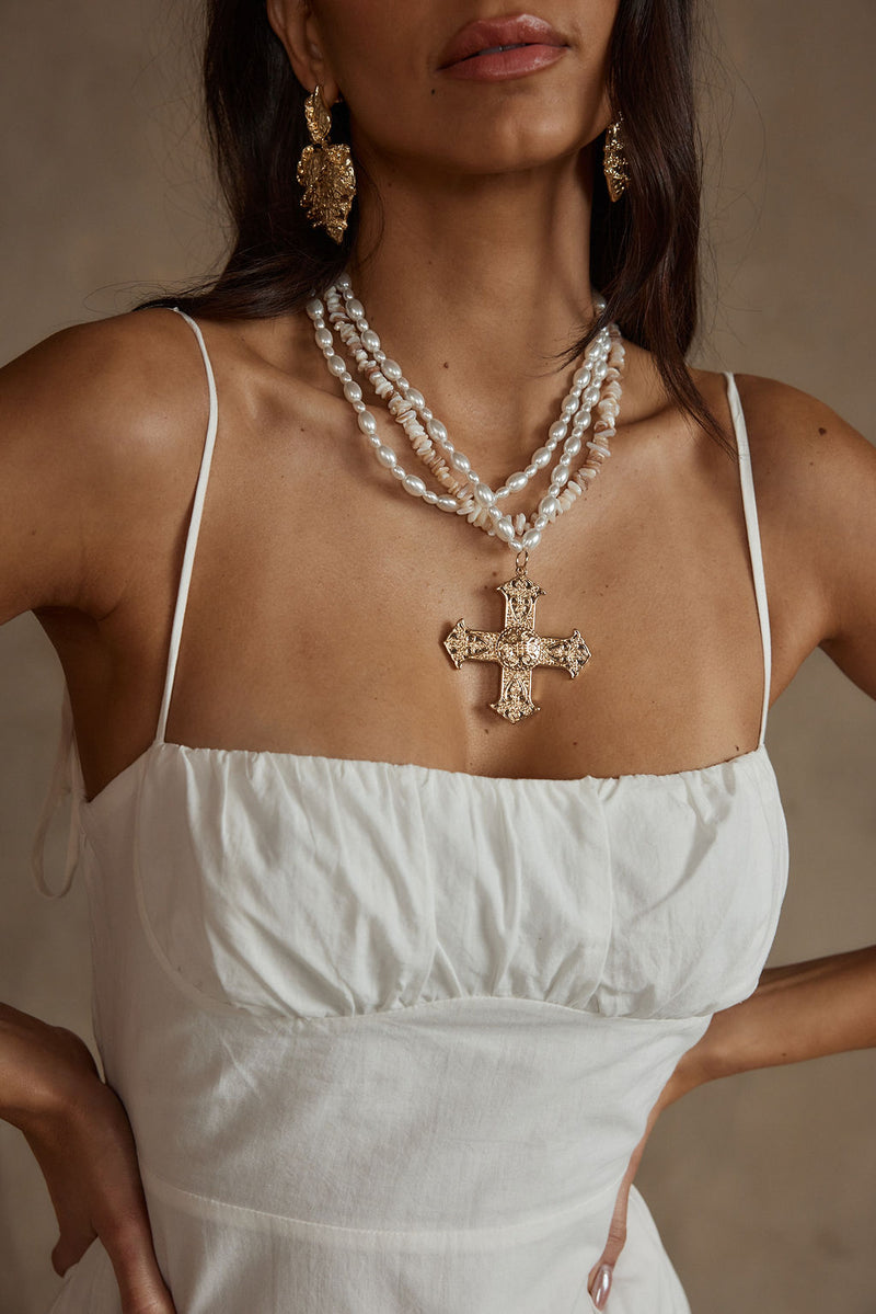 Close-up of the Angelica Gold Pearl Cross Statement Necklace showcasing the pearl texture and craftsmanship.