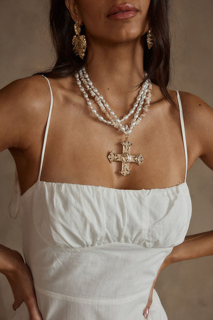 Close-up of the Angelica Gold Pearl Cross Statement Necklace showcasing the pearl texture and craftsmanship.