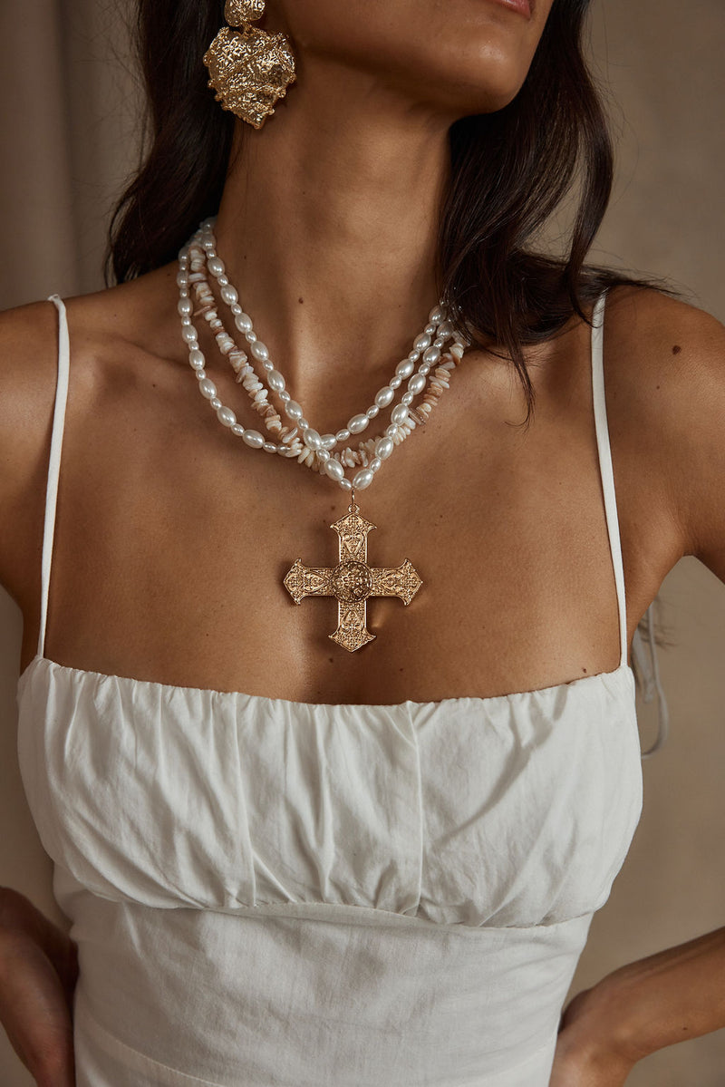 Angelica Gold Pearl Cross Statement Necklace shown as part of a styled outfit ensemble.