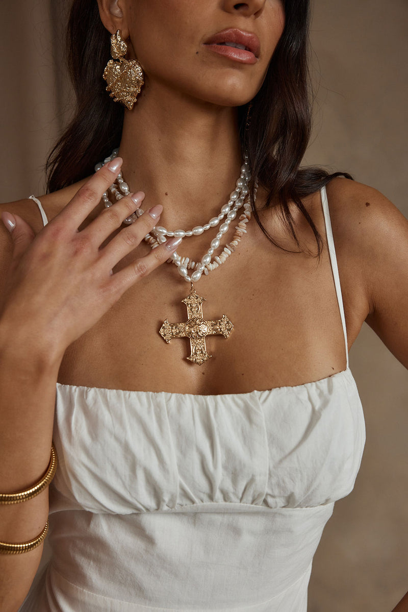 Detail shot of the Angelica Gold Pearl Cross Statement Necklace highlighting the pearl elements.