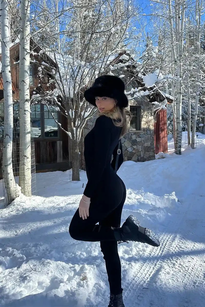 Full-length view of the black jumpsuit showing the drape and movement.