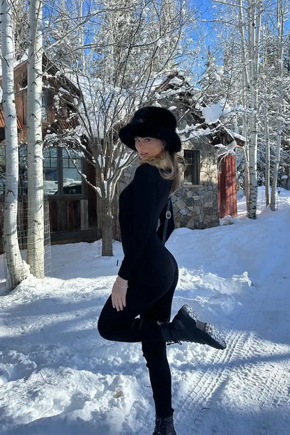 Full-length view of the black jumpsuit showing the drape and movement.