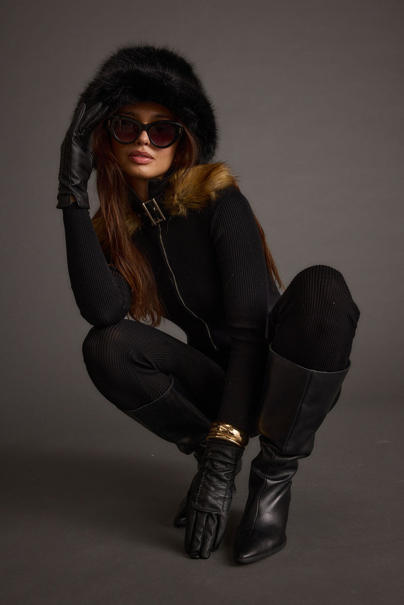 Detail shot of the Apres Faux Fur Trimmed Black Ribbed Knit Jumpsuit highlighting the knit and ribbed elements.