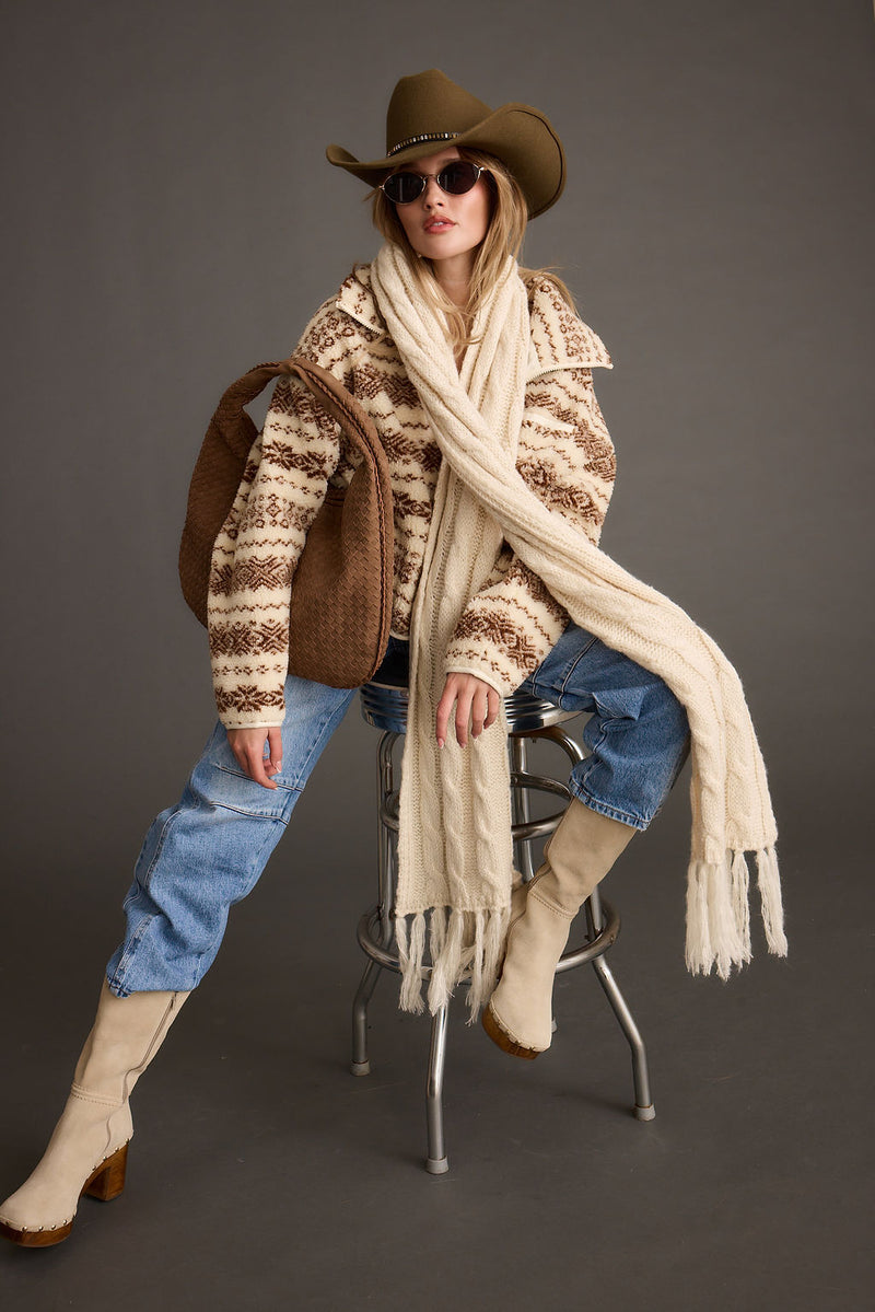 Cream printed sherpa jacket with brown western pattern, styled with jeans and a cowboy hat.