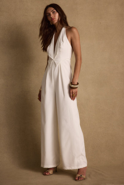 Full-length view of the white jumpsuit showing the drape and movement.