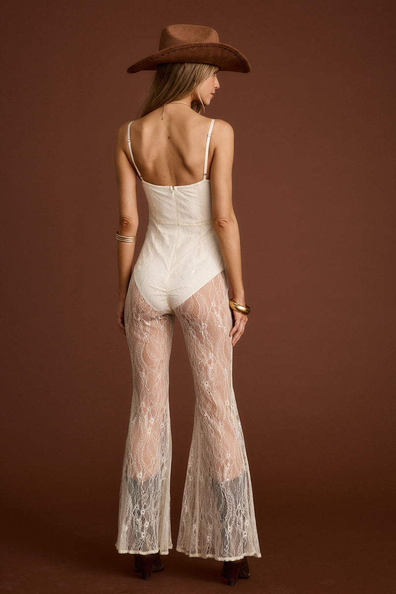 Full-length view of the cream jumpsuit showing the drape and movement.