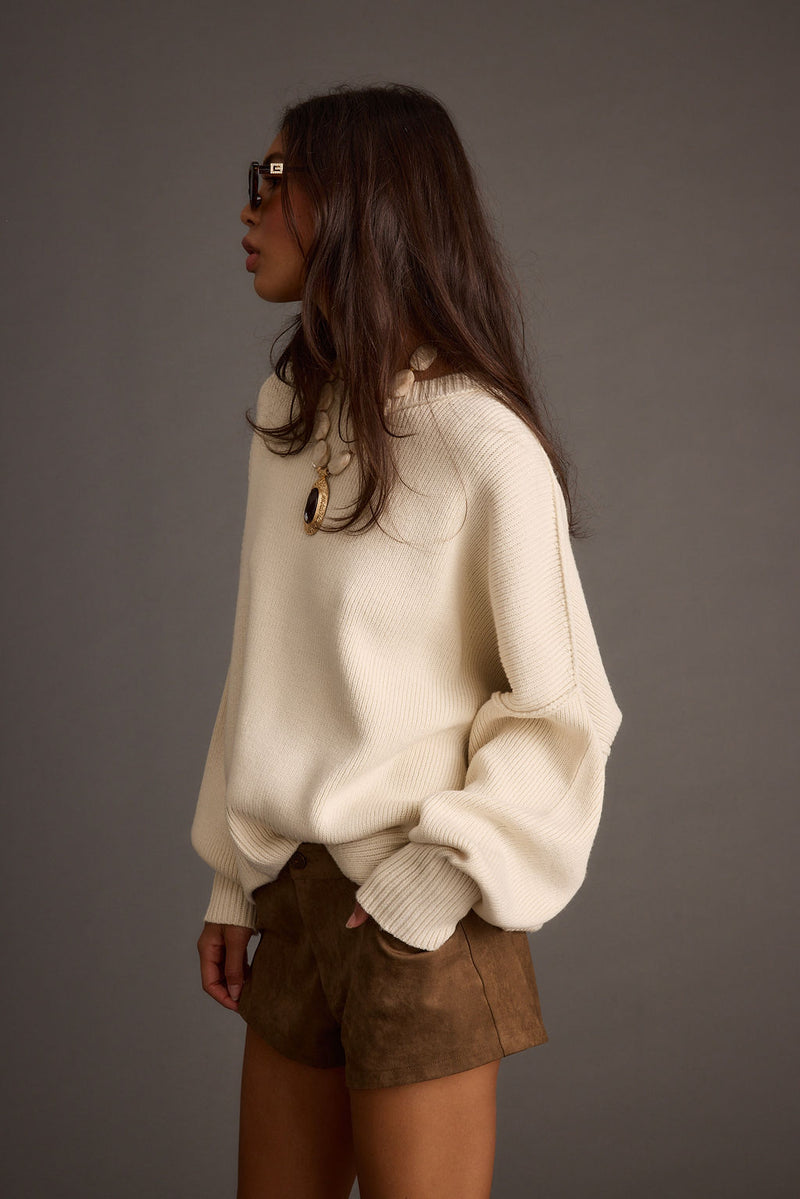 Alternate angle of the cream sweater highlighting the overall design.