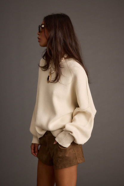 Alternate angle of the cream sweater highlighting the overall design.