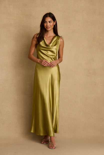Model wearing the 12th Tribe Mirabella Chartreuse Satin Maxi Dress in vibrant Spring ready green satin, featuring a flowing maxi silhouette and elegant cowl neckline. Style with strappy heels for vacations bachelorette parties, weddings, and summer events.