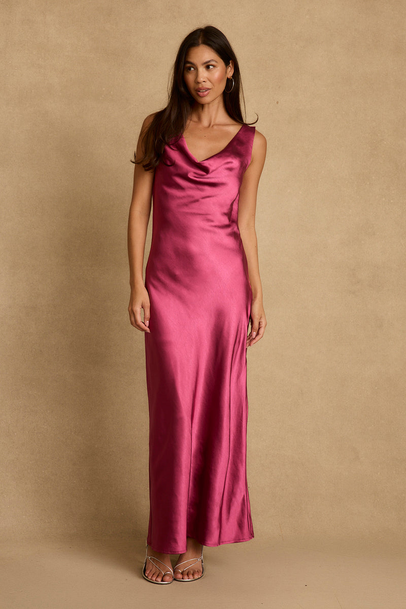 Model wearing the 12th Tribe Dolce Fuchsia Satin Maxi Dress in a bold fuchsia satin. Featuring a fluid maxi silhouette and high-shine finish. Style with heels for bachelorette parties, weddings, and evening outings.