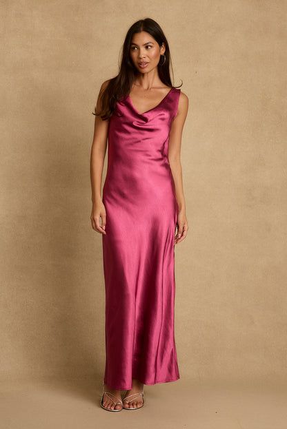 Model wearing the 12th Tribe Dolce Fuchsia Satin Maxi Dress in a bold fuchsia satin. Featuring a fluid maxi silhouette and high-shine finish. Style with heels for bachelorette parties, weddings, and evening outings.