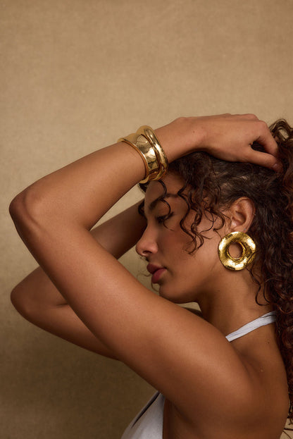 Full-length view of the gold piece showing the drape and movement.