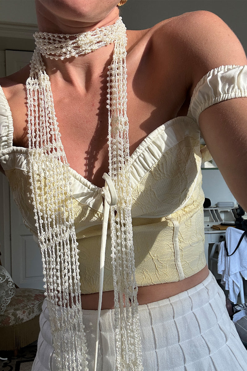 Yellow corset top with refined detailing and a flattering silhouette.