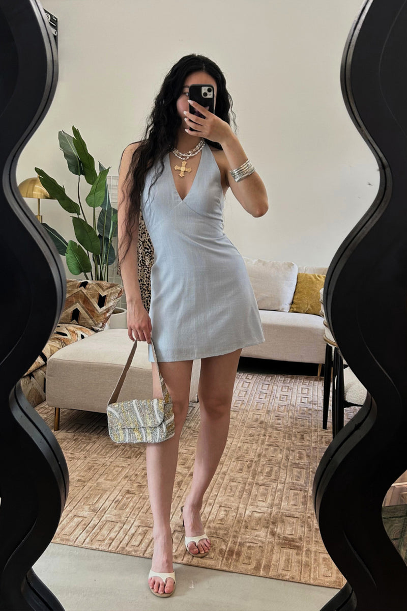 Lifestyle shot of the blue mini dress styled for day-to-night versatility.