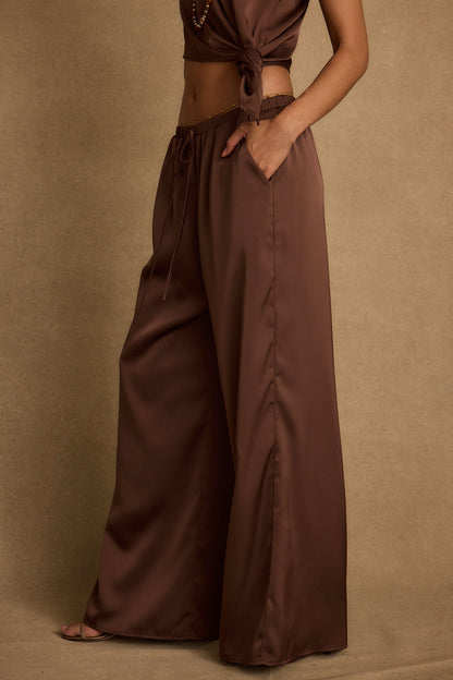 Lifestyle shot of the espresso pants styled for day-to-night versatility.