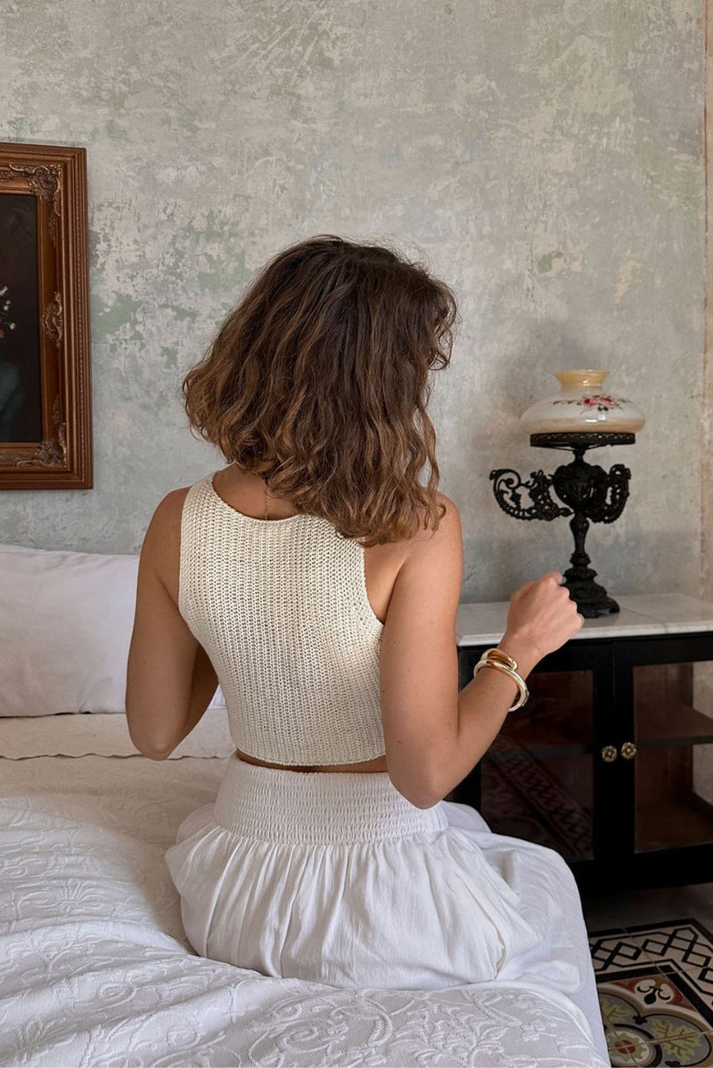 Back view of the cream knit vest showing the silhouette and fit.