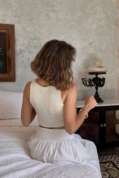 Back view of the cream knit vest showing the silhouette and fit.