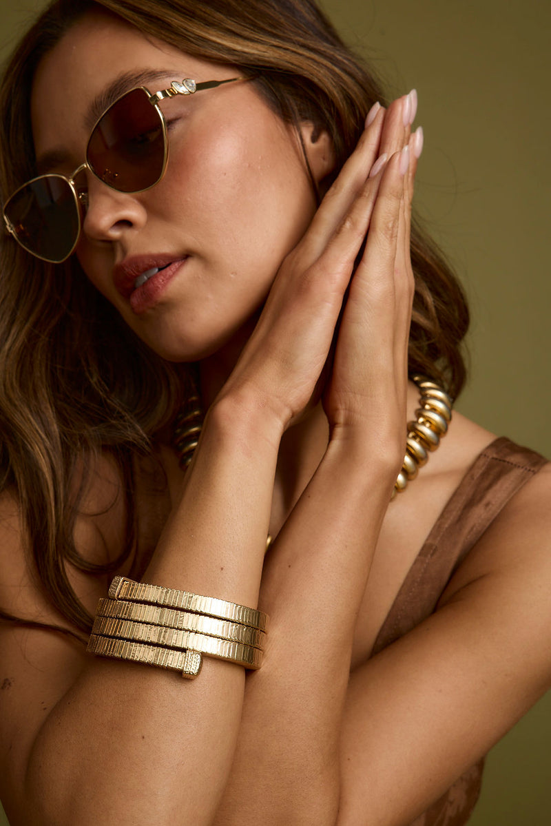 Close-up of the Forevermore Gold Metal Bangle showcasing the fabric texture and design details.