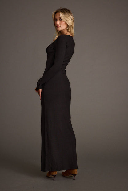 Back view of the black ribbed maxi dress showing the silhouette and fit.