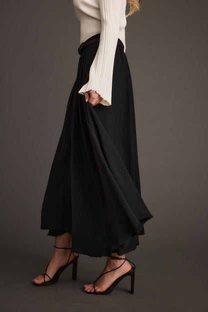 Close-up of the Gloria Black Midi Skirt showcasing the fabric texture and design details.