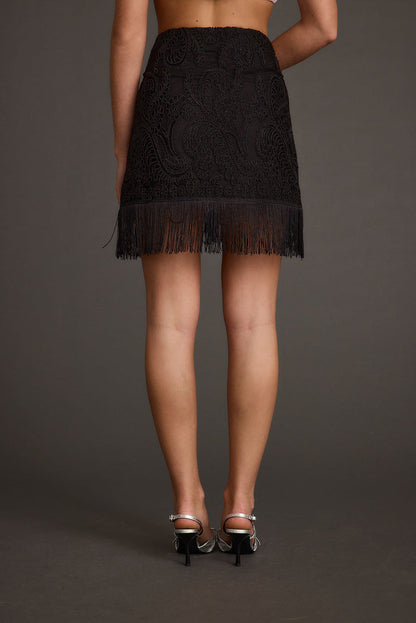 Back view of the black fringe mini skirt showing the silhouette and fit.