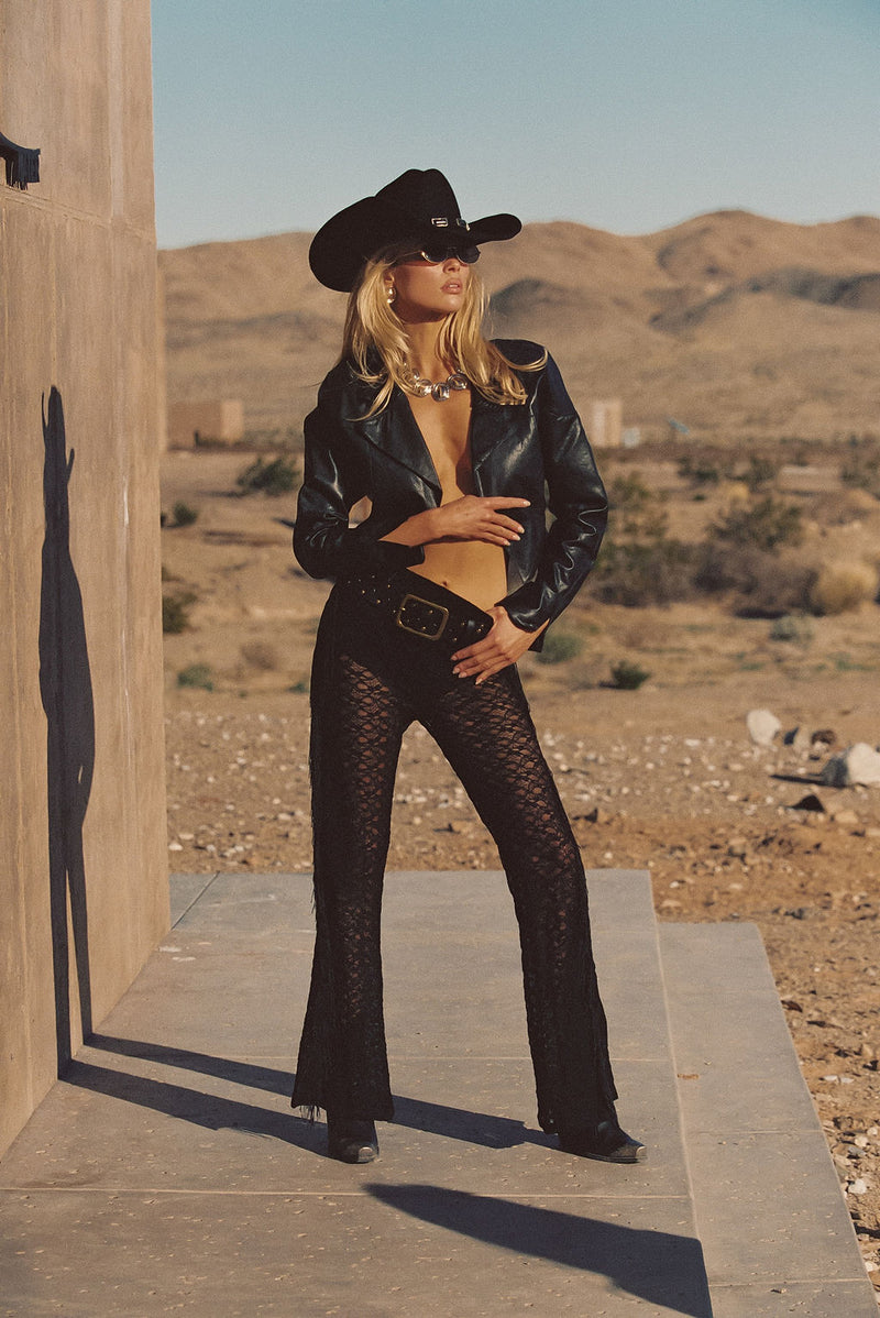 Back view of the black fringe pants showing the silhouette and fit.