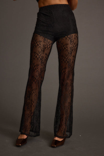 Back view of the black lace pants showing the silhouette and fit.