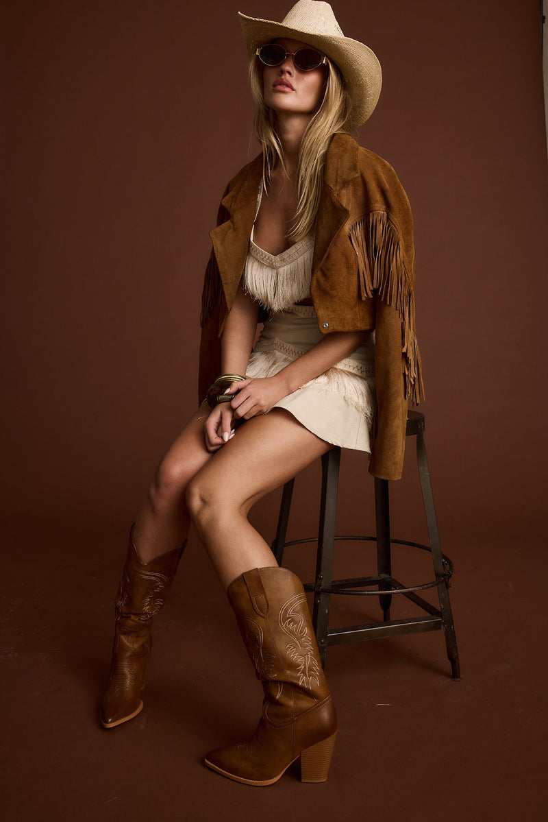 Full-length view of the ivory mini dress showing the drape and movement.