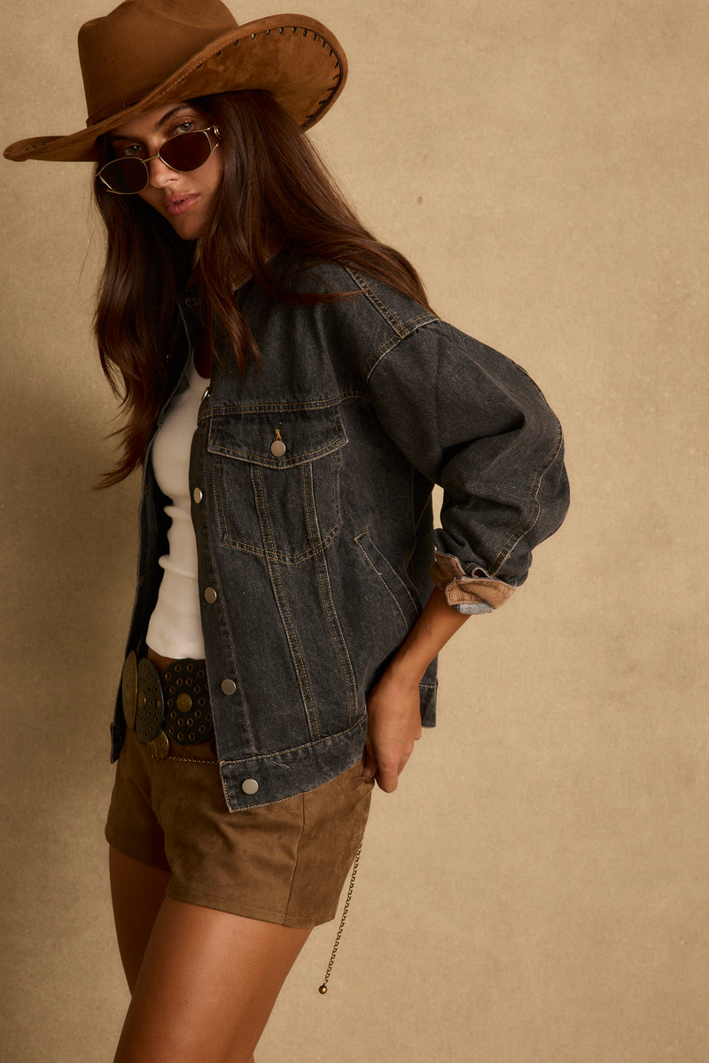 Back view of the black denim barn jacket showing the silhouette and fit.