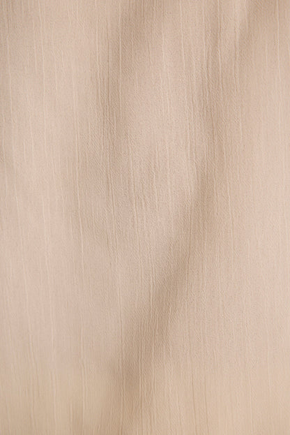 Close-up of ivory crinkle-textured sheer fabric used in the Jada halter top.