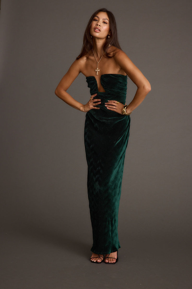 Full-length view of the emerald maxi dress showing the drape and movement.