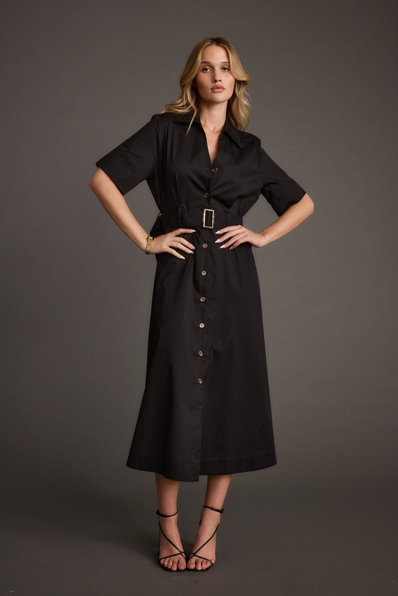 Full-length view of the black midi dress showing the drape and movement.