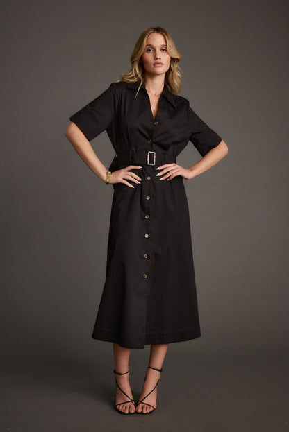 Full-length view of the black midi dress showing the drape and movement.