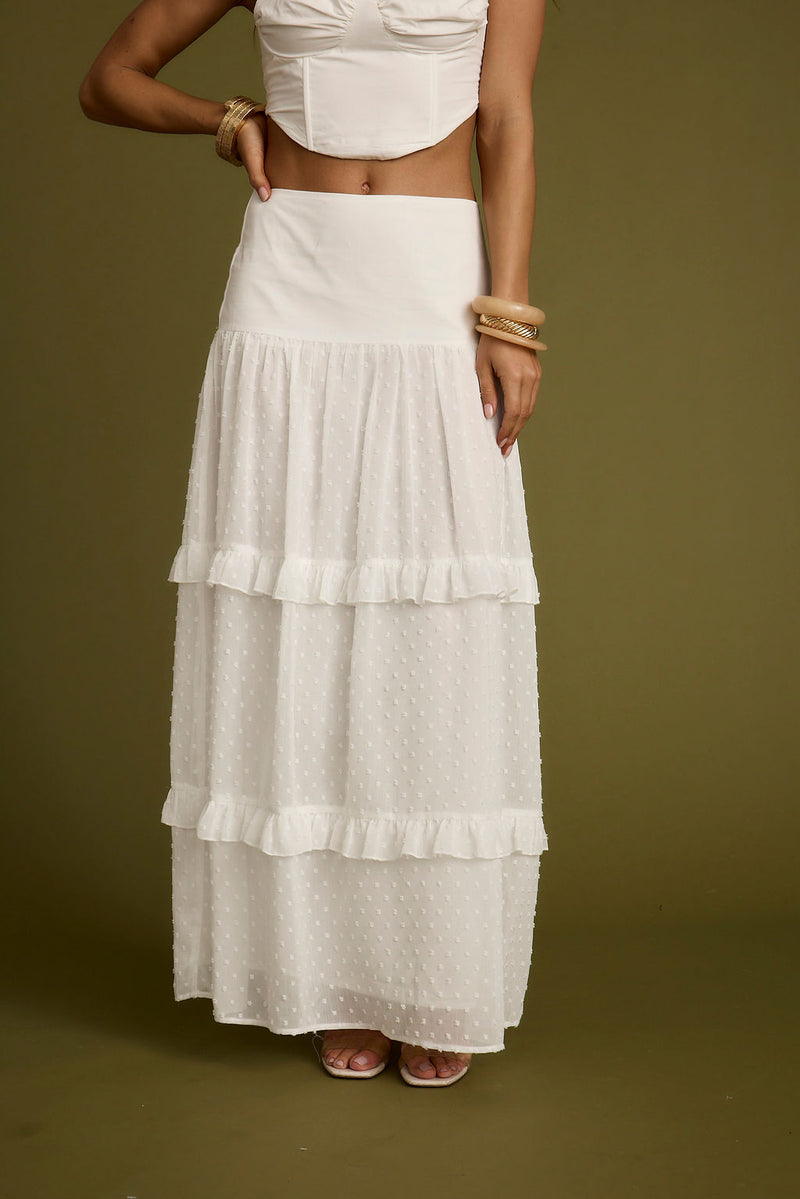 Full-length view of the white maxi skirt showing the drape and movement.