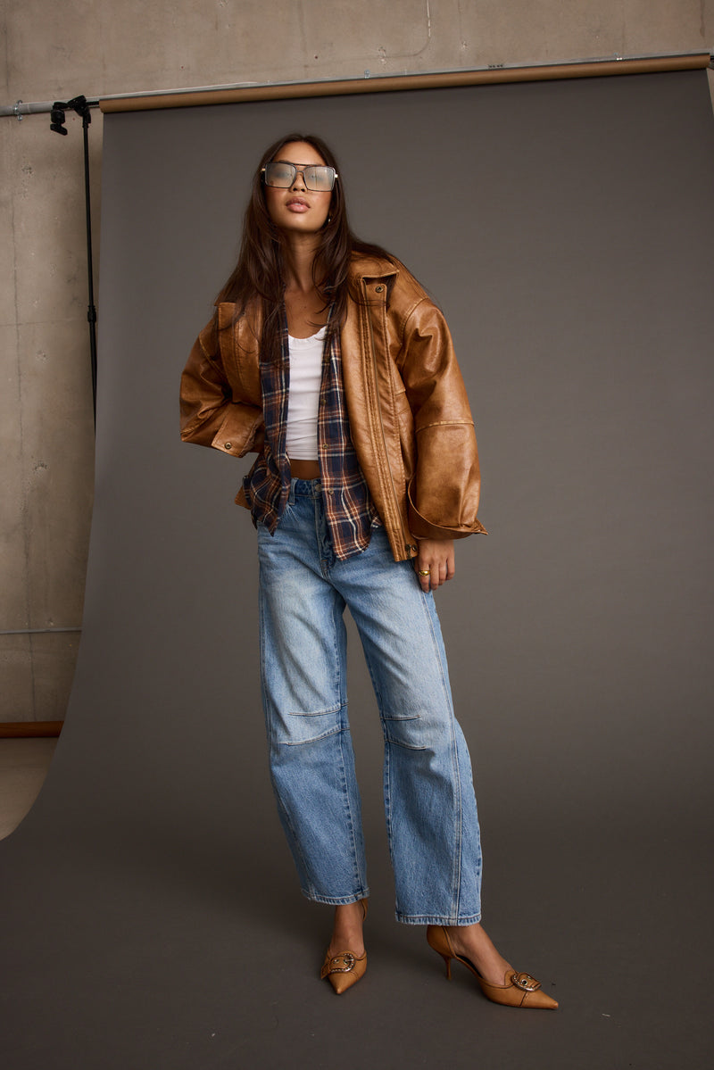 Back view of the cognac faux leather and leather jacket showing the silhouette and fit.