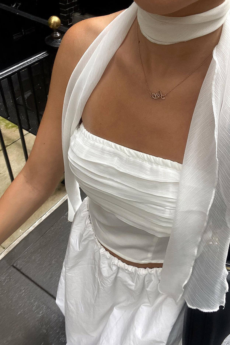 White strapless top with elegant accents, a white feather top essential.