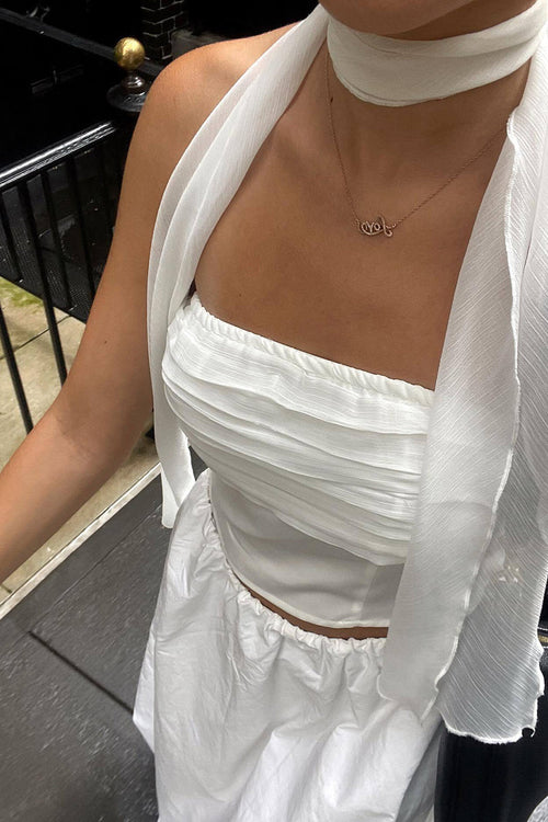 White strapless top with elegant accents, a white feather top essential.