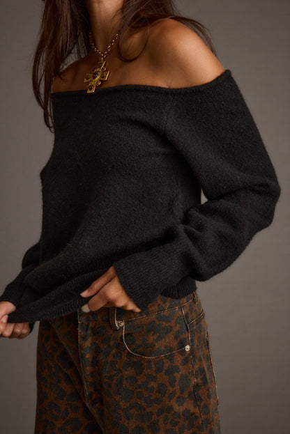 Full-length view of the black sweater showing the drape and movement.