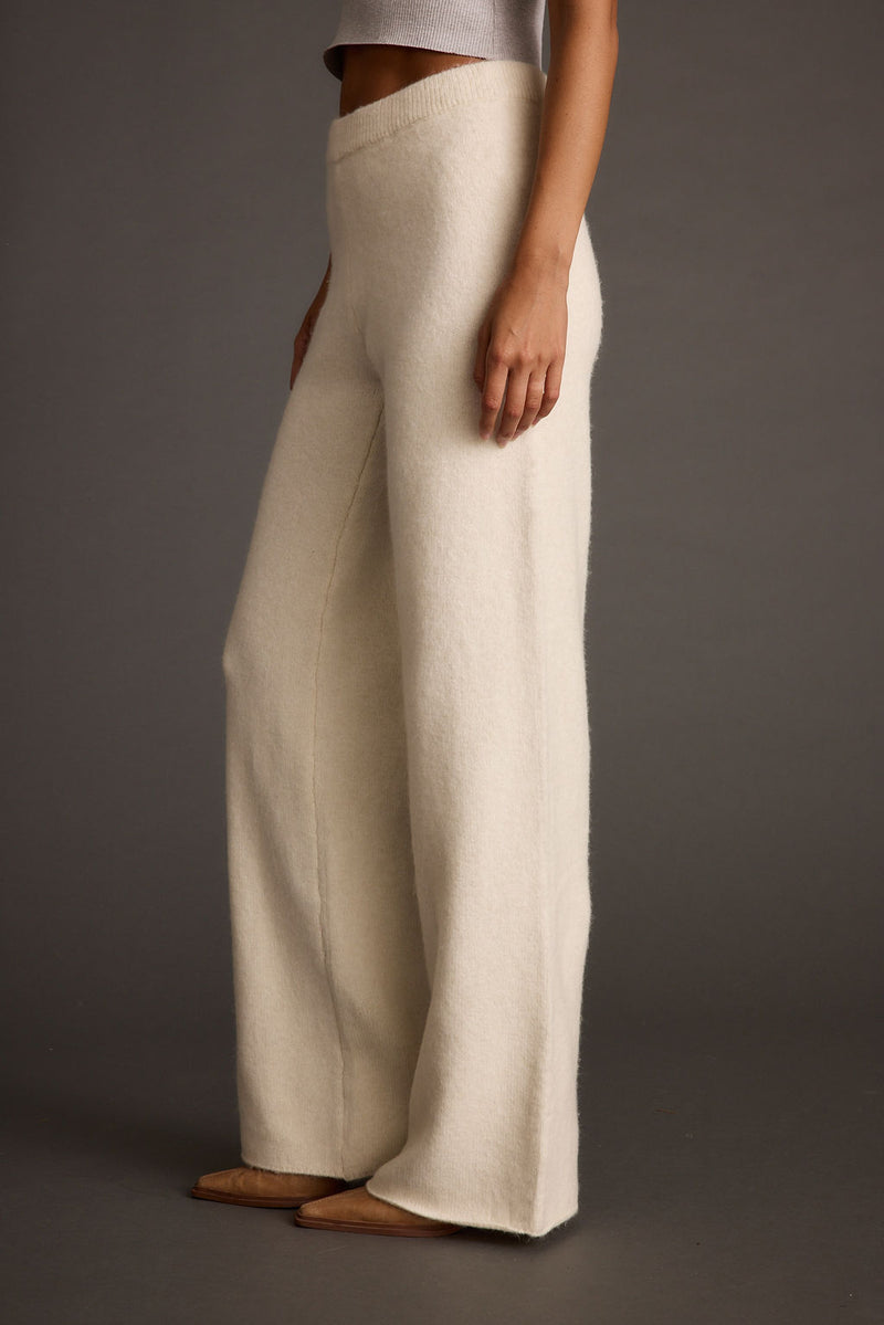 Back view of the ivory sweater showing the silhouette and fit.