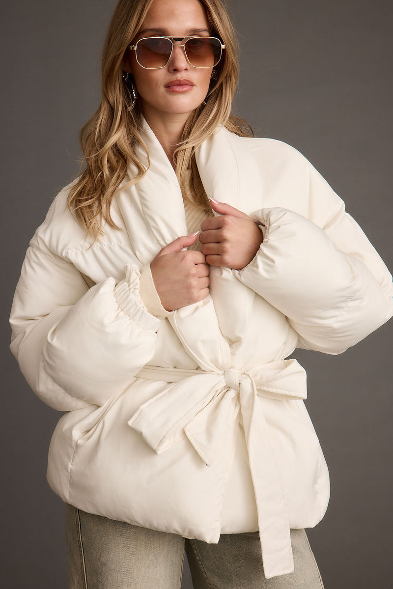 Full-length view of the white jacket showing the drape and movement.