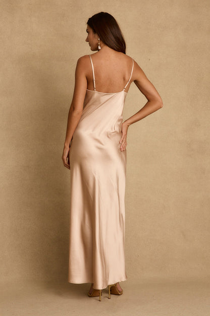 Back view of champagne satin maxi dress with thin straps and floor-length skirt.
