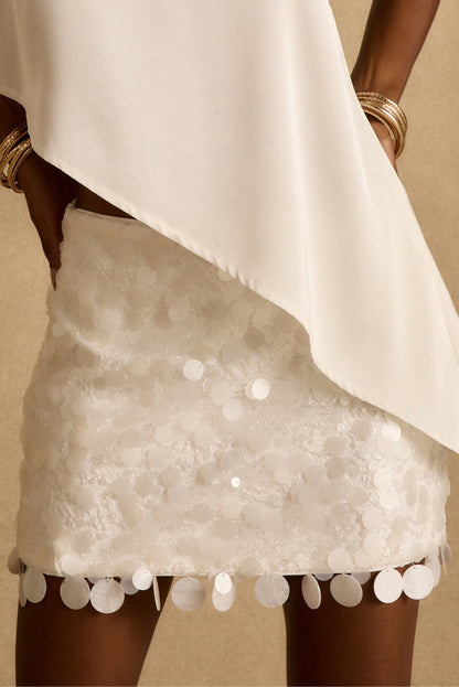 Model wearing the 12th Tribe Miramar White Payette Mini Skirt, a best-selling fully lined white payette mini skirt featuring a low rise fit for a bride ready finish. Perfect for resort wear, bridesmaids vibes. and bachelorette moments.
