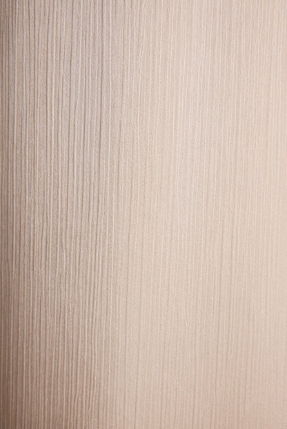 Lifestyle shot of the cream trousers styled for day-to-night versatility.